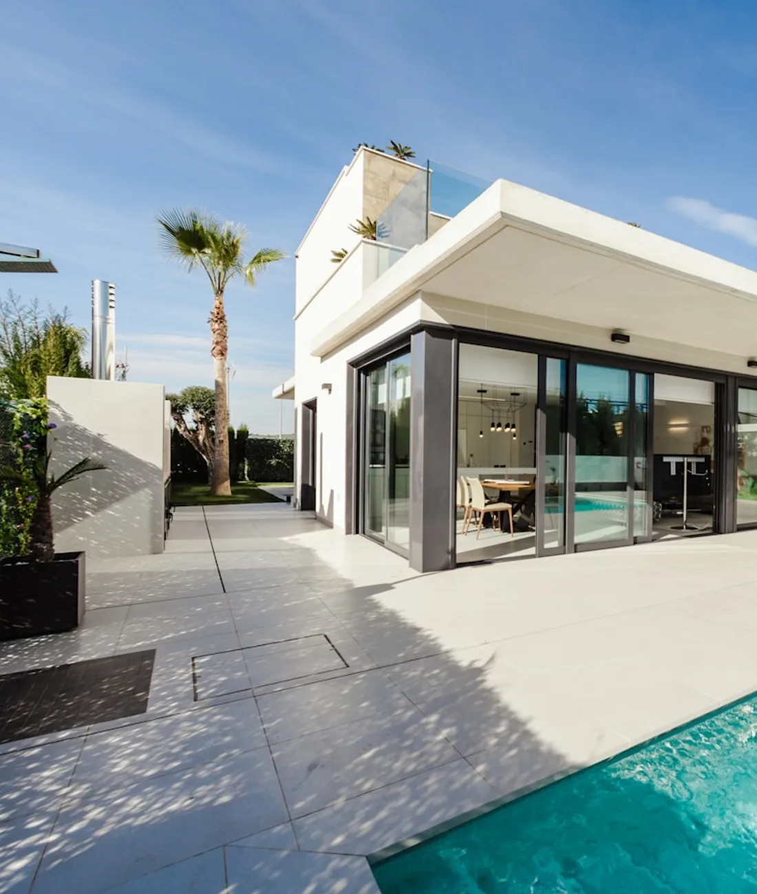 Weißes Wohnhaus mit Pool und großen Fensterfronten