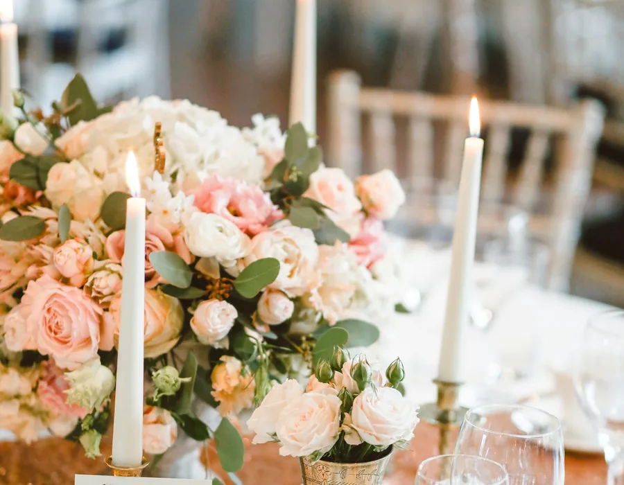 Rosen und hohe Kerzen als Tischschmuck