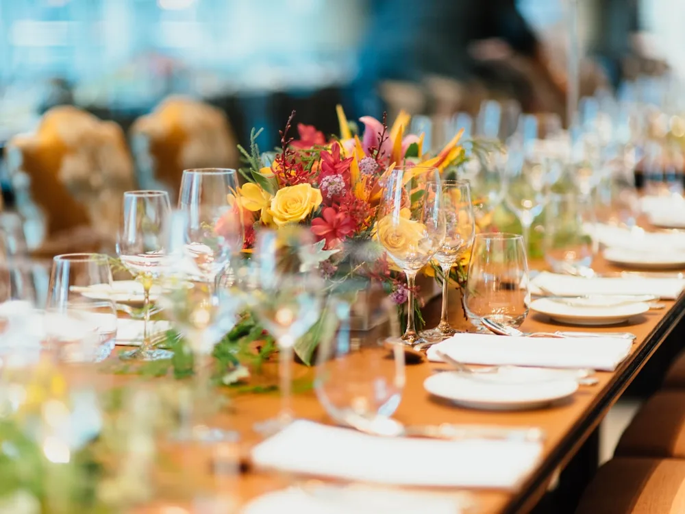 Lange festliche Abendtafel mit Blumen und Gläsern
